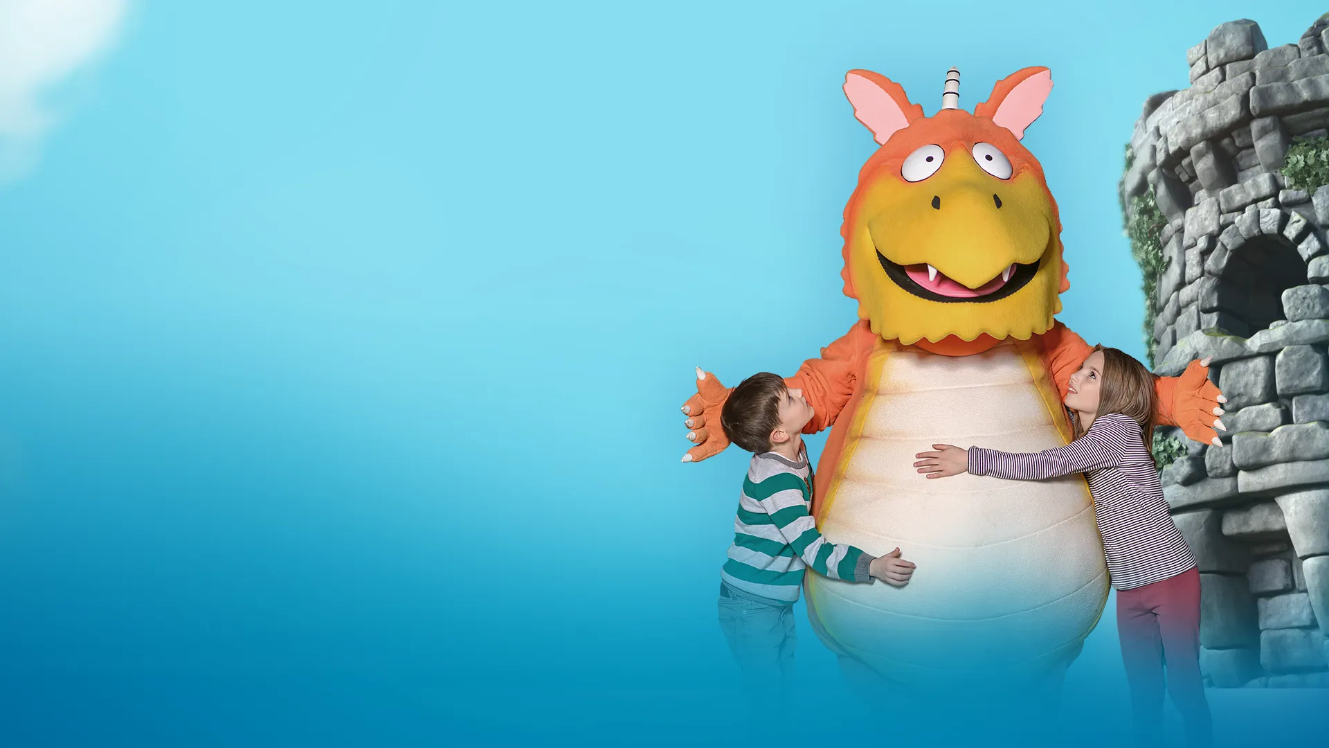 Children interacting with Zog customer character with CGI background featuring blue sky and a castle